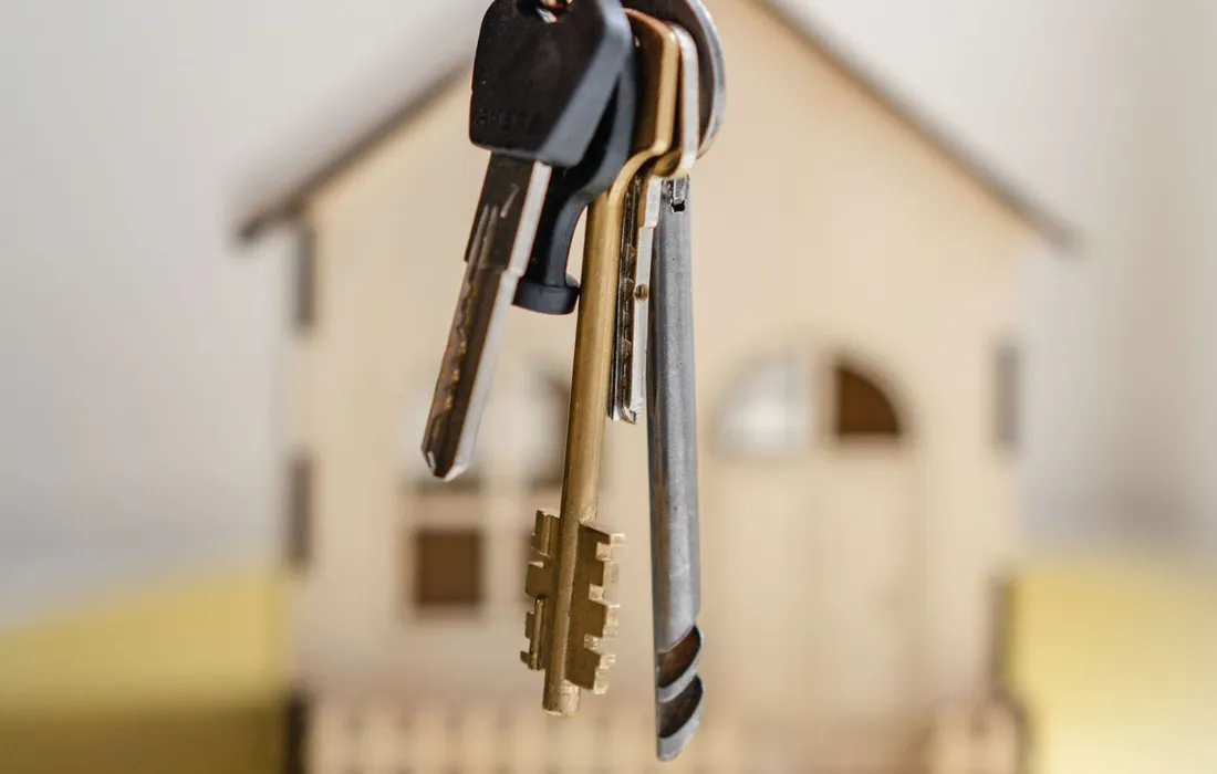 Casa de madera en miniatura blanca y roja sobre una mesa, simbolizando la vivienda propia con subsidio DS1