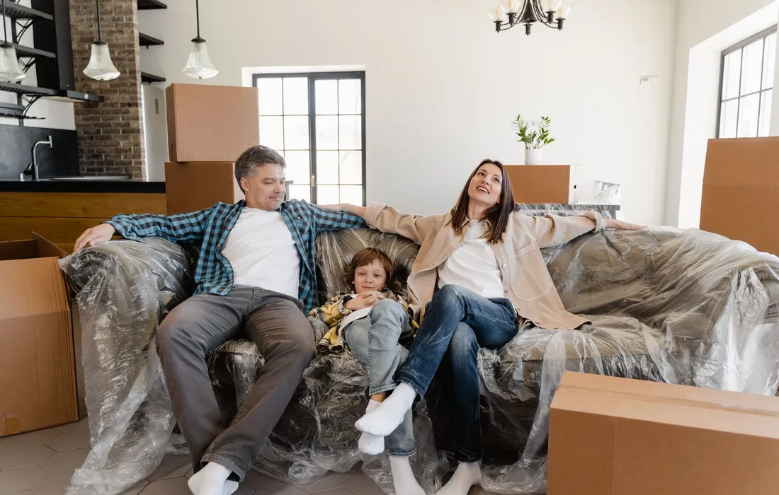 Niños sentados en el living de su nueva vivienda